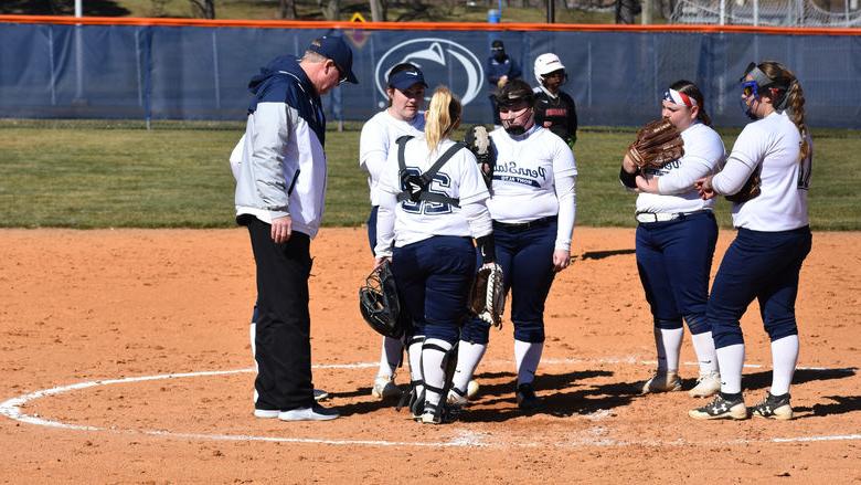 Women's softball players convene on the mound